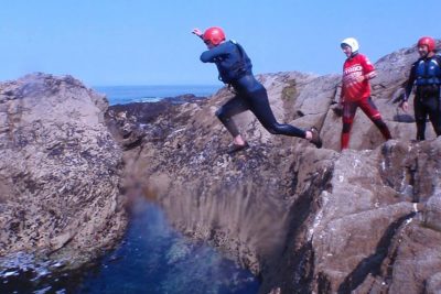 man jumping off rocks