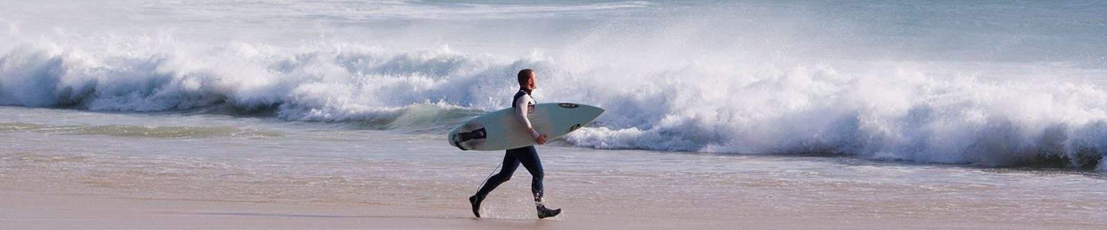 man carrying a surf board