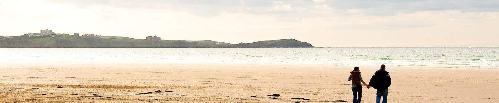 couple holding hands on the beach in winter