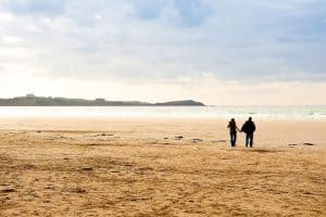 couple holding hands on the beach in winter