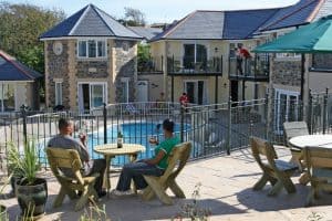 People drinking wine in the seating area overlooking the heated outdoor pool