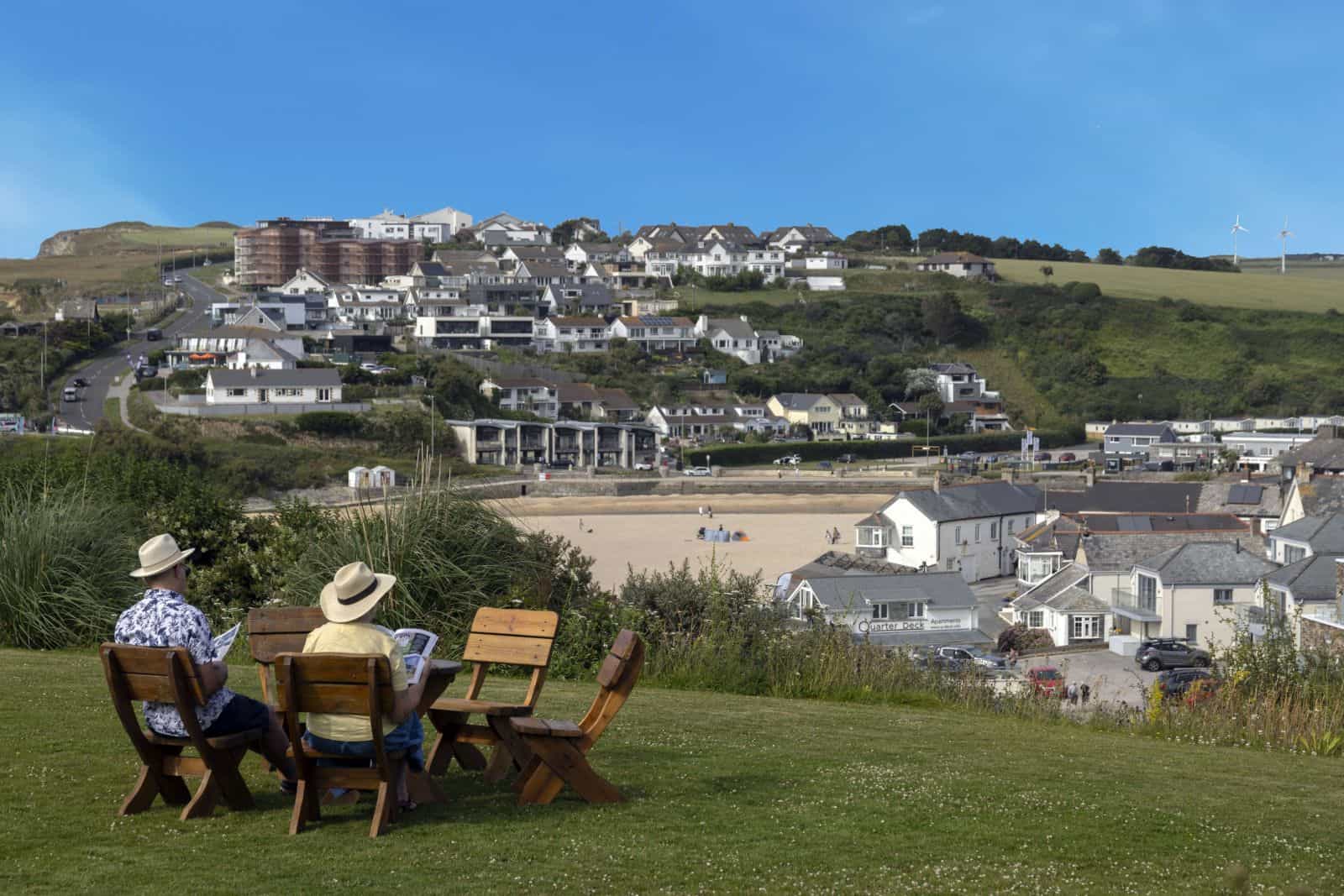 Couple sat in the garden, overlooking Porth Beach